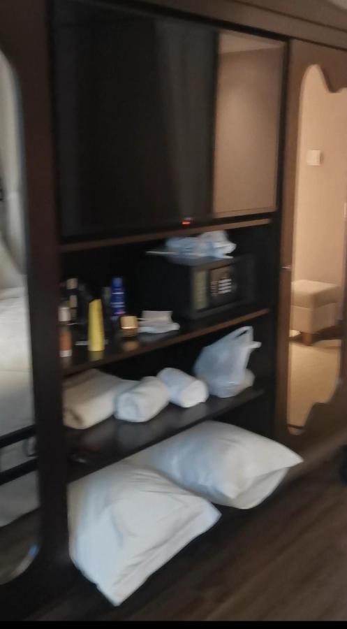 Buona Vitta Gramado Resort & Spa By Gramado Parks エクステリア 写真 The photo shows a piece of furniture, likely a shelving unit or cabinet, with several items on it. There is a television mounted on top. Below the TV, there is a microwave and a small safe. The shelves contain various toiletries and personal care pro