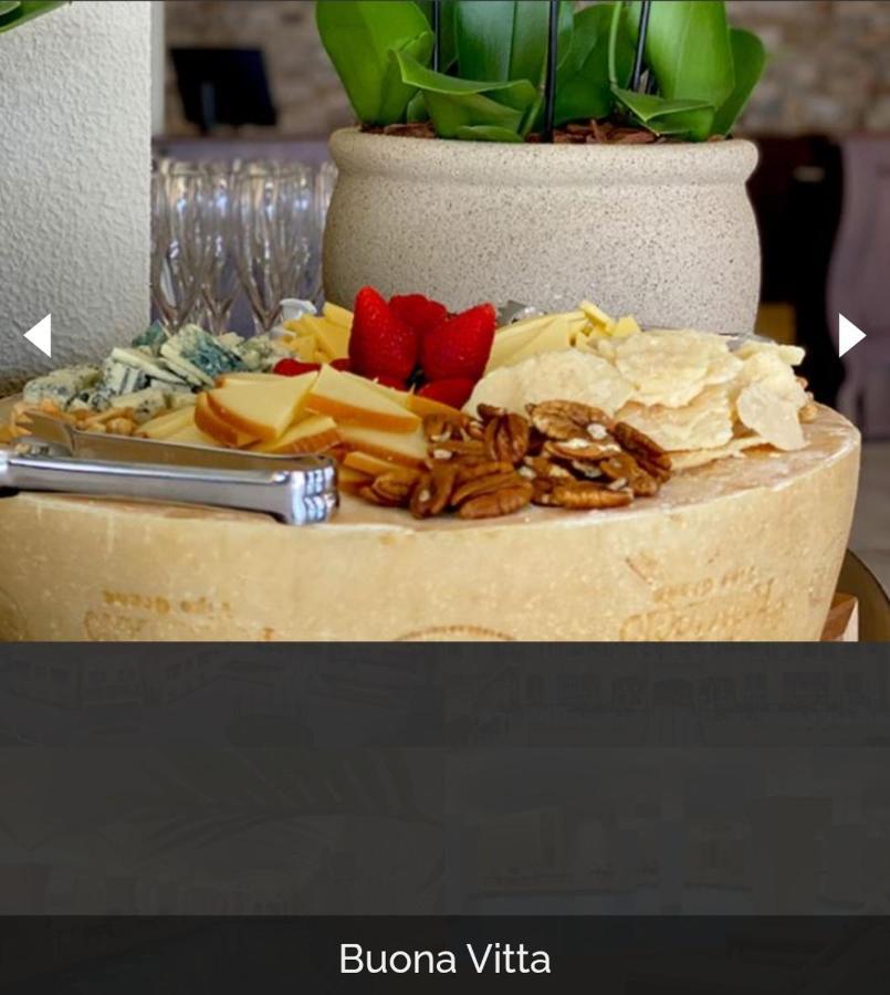 Buona Vitta Gramado Resort & Spa By Gramado Parks エクステリア 写真 The photo displays a beautiful cheese platter. It features a large round cheese wheel as the base, surrounded by various types of cheeses including soft and hard varieties. There are also some crackers or crisps, along with nuts, particularly pecans.