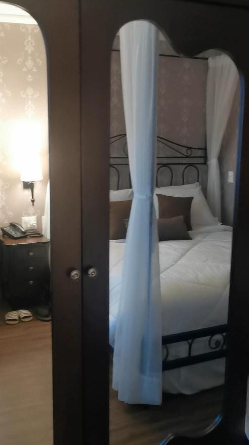 Buona Vitta Gramado Resort & Spa By Gramado Parks エクステリア 写真 The photo shows a cozy bedroom scene. It features a bed with white bedding and several brown accent pillows. The bed is framed by a decorative headboard and appears to be situated against a wall with subtle patterns. Next to the bed, there is a night