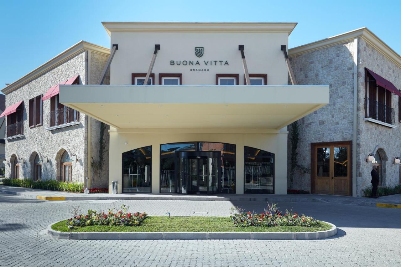 Buona Vitta Gramado Resort & Spa By Gramado Parks エクステリア 写真 The photo shows a modern building with a prominent entrance marked by a large awning. The facade features a mix of stone and stucco materials, giving it an elegant and contemporary look. The name "BUONA VITTA" is displayed prominently above the entra