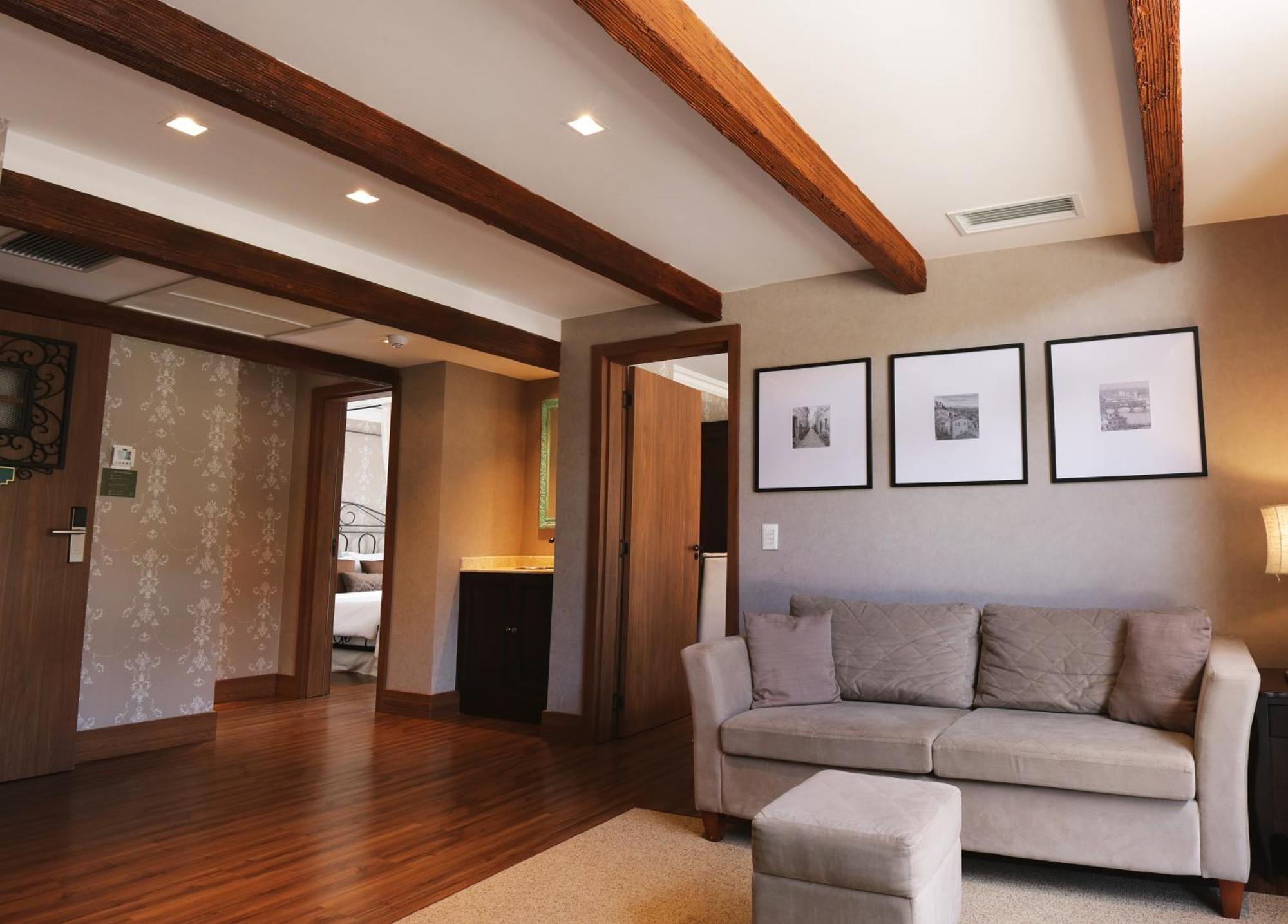 Buona Vitta Gramado Resort & Spa By Gramado Parks エクステリア 写真 The photo showcases a modern living space with a cozy and well-lit atmosphere. There are wooden beams visible on the ceiling, adding a rustic touch. The flooring is a warm-toned wood, contributing to the inviting feel of the room. 

On one side, ther