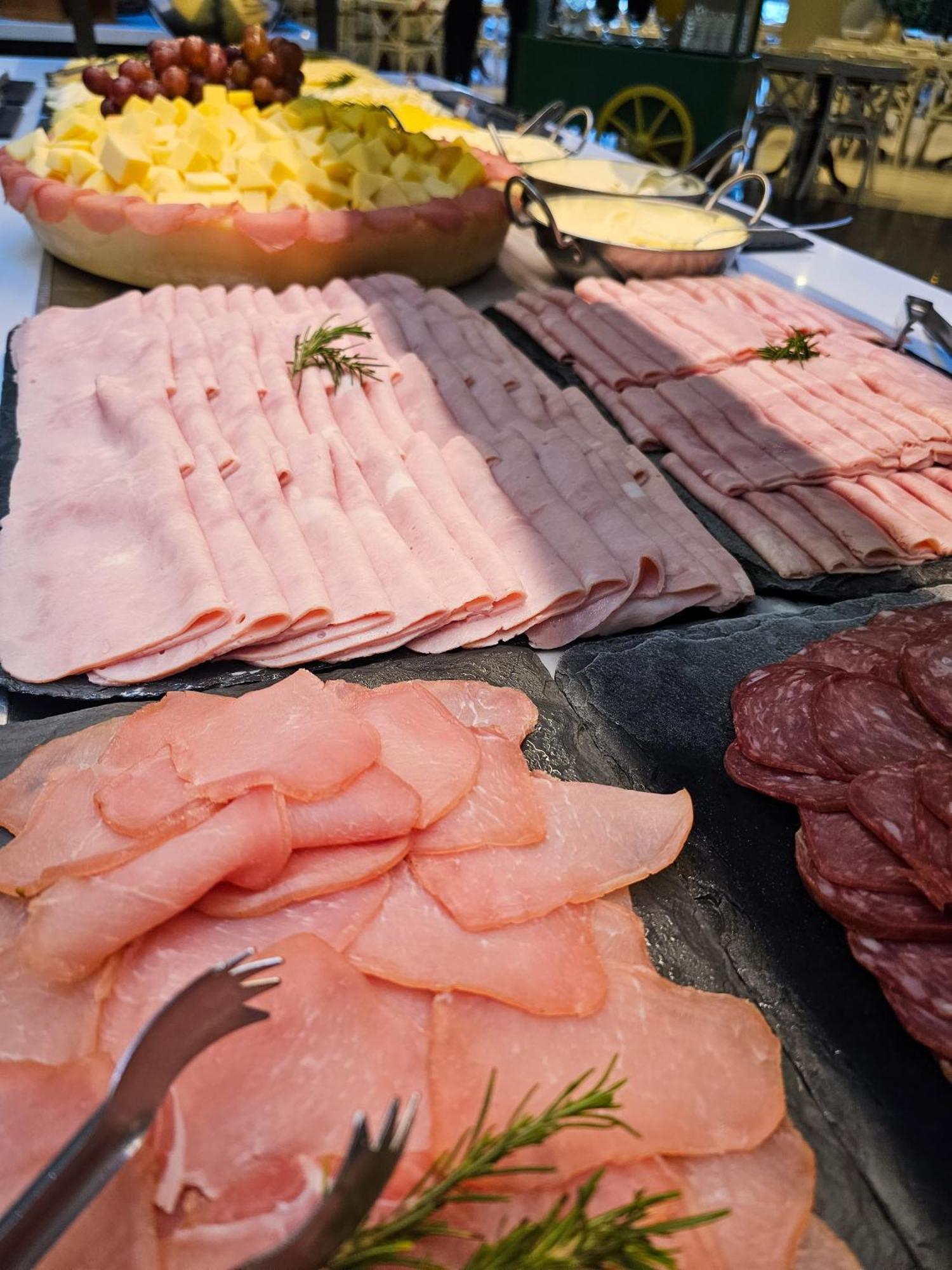 Buona Vitta Gramado Resort & Spa By Gramado Parks エクステリア 写真 The photo shows a display of various types of sliced deli meats arranged on a flat surface. There are several layers of thinly sliced, pale-colored meats, likely including ham or turkey, organized neatly in parallel rows. Additionally, there are slic